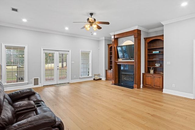 living room with french doors, light wood-type flooring, ceiling fan, and ornamental molding