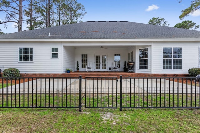 rear view of house with french doors, a yard, and ceiling fan