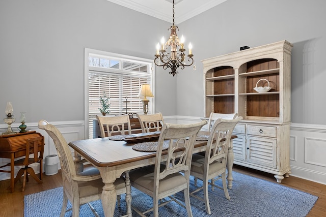 dining room featuring dark hardwood / wood-style flooring, crown molding, and a notable chandelier