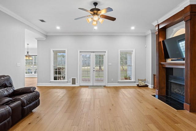 living room with plenty of natural light, ceiling fan, ornamental molding, and light hardwood / wood-style flooring