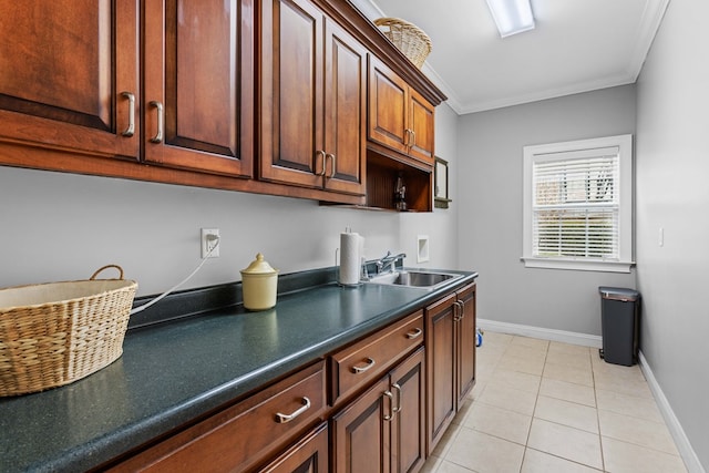 kitchen with crown molding, sink, and light tile patterned floors