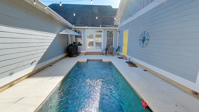 view of swimming pool featuring french doors and a patio area