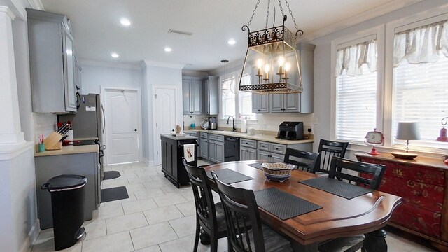 kitchen featuring gray cabinetry, decorative light fixtures, black dishwasher, and a wealth of natural light