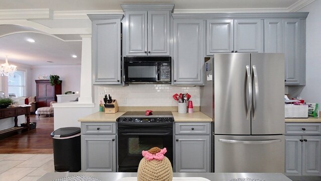 kitchen with black appliances, gray cabinetry, and crown molding