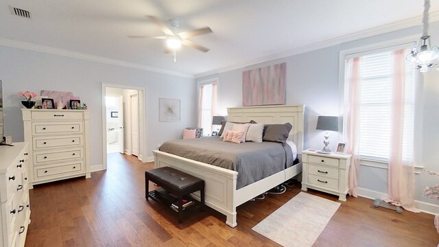 bedroom featuring dark hardwood / wood-style floors, ceiling fan, and crown molding