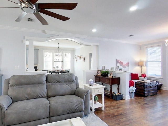 living room featuring ceiling fan with notable chandelier, dark hardwood / wood-style floors, and ornamental molding