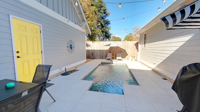 view of pool featuring pool water feature, a grill, and a patio