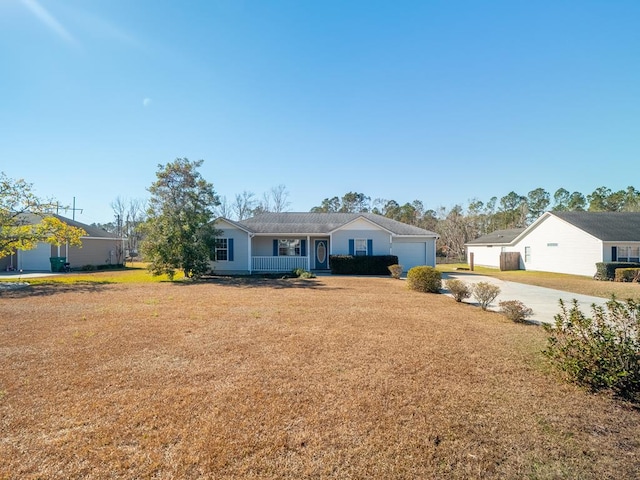 ranch-style home with covered porch, a garage, and a front yard