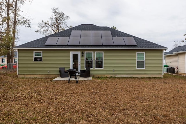 back of house with solar panels and a patio area