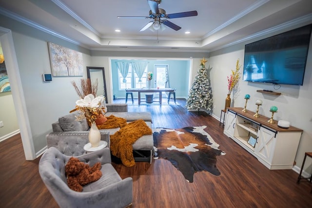 living room with ceiling fan, ornamental molding, and a tray ceiling