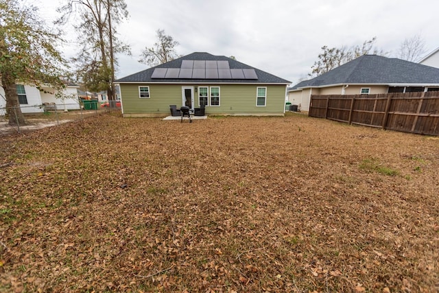 rear view of property with solar panels and a patio area