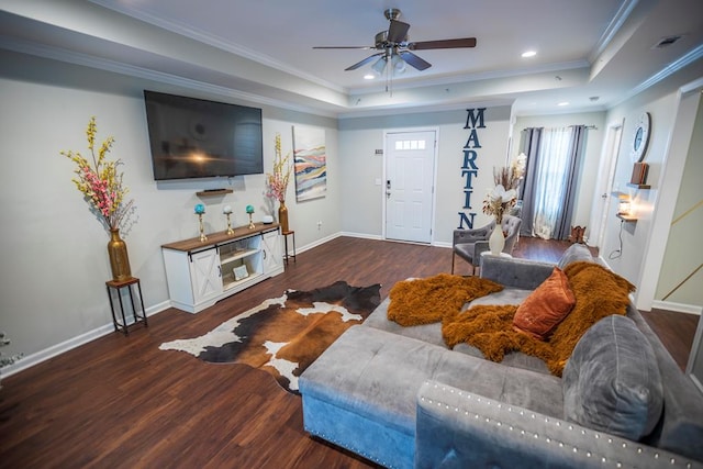 living room featuring ceiling fan, ornamental molding, and a tray ceiling