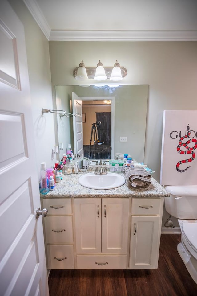 bathroom featuring hardwood / wood-style floors, vanity, toilet, and crown molding