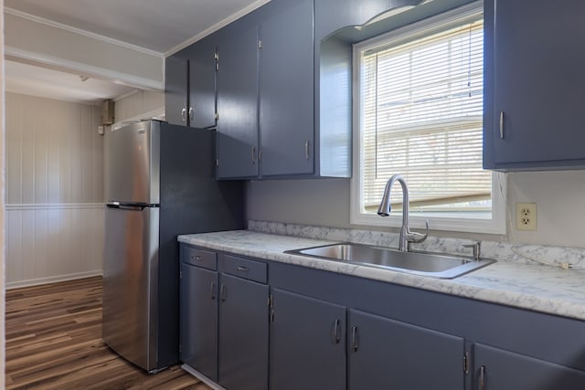 kitchen featuring blue cabinetry, sink, dark wood-type flooring, stainless steel fridge, and ornamental molding