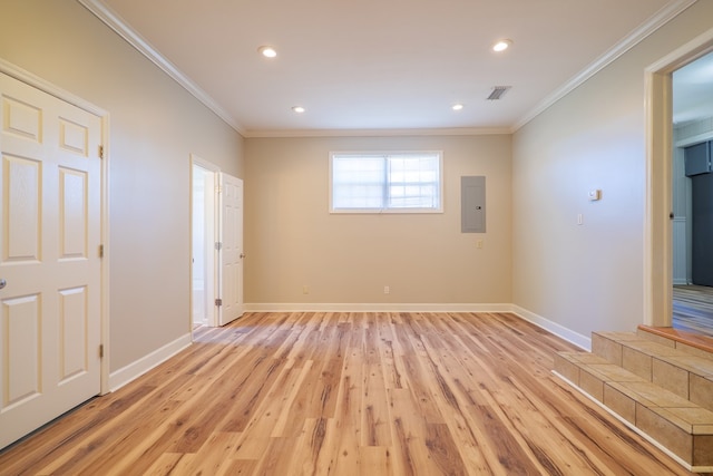 unfurnished room with light wood-type flooring, electric panel, and crown molding