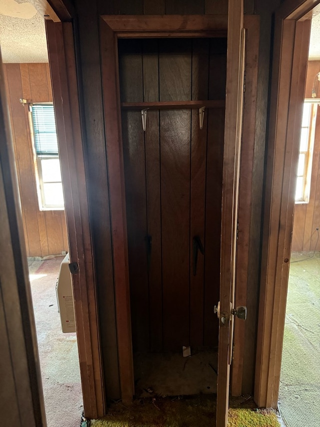 hallway with wood walls and a textured ceiling