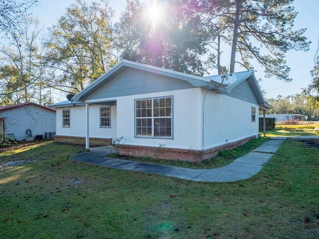 back of property with central AC and a yard