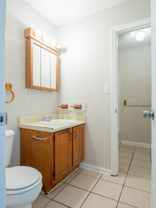 bathroom with tile patterned flooring, vanity, and toilet