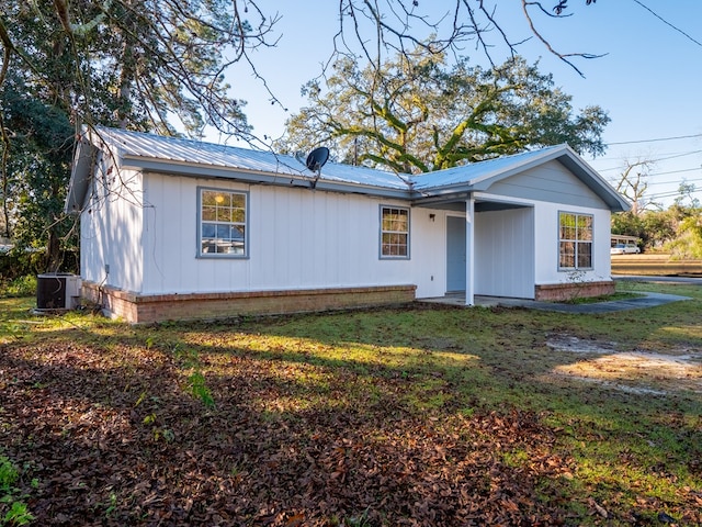 view of front of home with cooling unit and a front yard