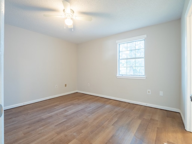 empty room with ceiling fan, light hardwood / wood-style flooring, and a textured ceiling