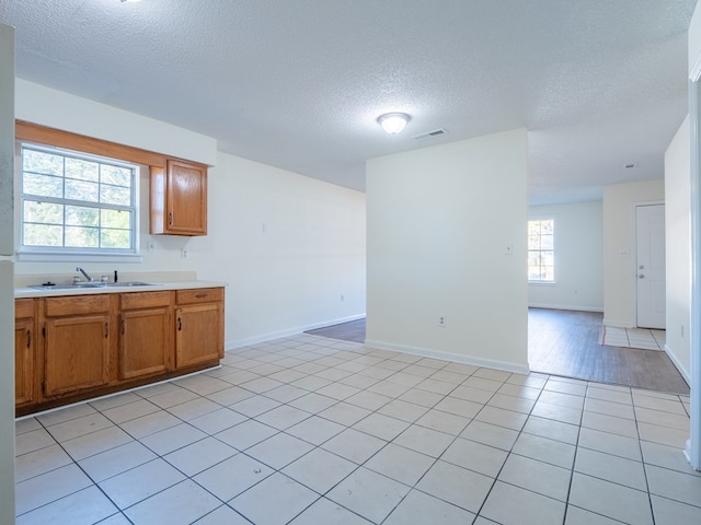 kitchen featuring sink, light tile patterned floors, and a textured ceiling