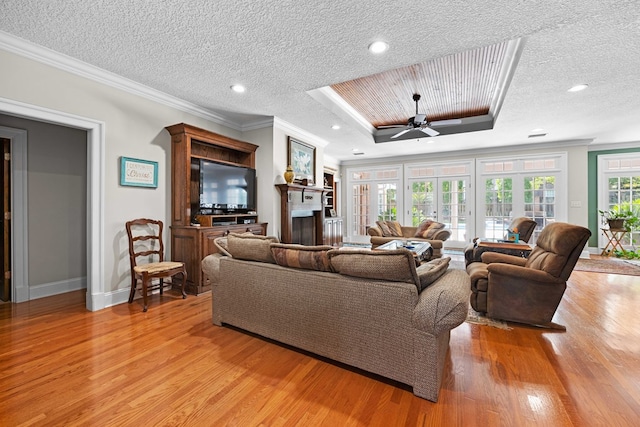 4155 Quail Run Cir, Valdosta, GA 31601 - living area with light wood-style floors, a raised ceiling, a ceiling fan, ornamental molding, and a textured ceiling