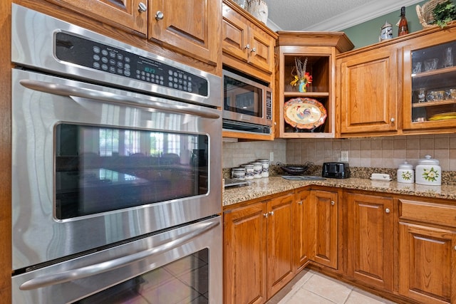 4155 Quail Run Cir, Valdosta, GA 31601 - kitchen with stainless steel appliances, crown molding, tasteful backsplash, light stone countertops, and a textured ceiling
