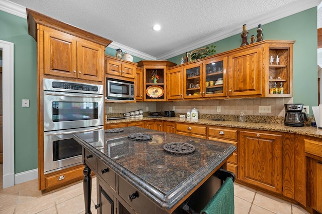 4155 Quail Run Cir, Valdosta, GA 31601 - kitchen featuring open shelves, appliances with stainless steel finishes, brown cabinets, decorative backsplash, and dark stone counters