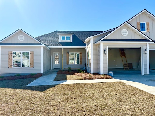 view of front of house featuring roof with shingles, concrete driveway, an attached garage, board and batten siding, and a front lawn