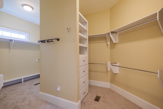 spacious closet featuring light colored carpet and visible vents