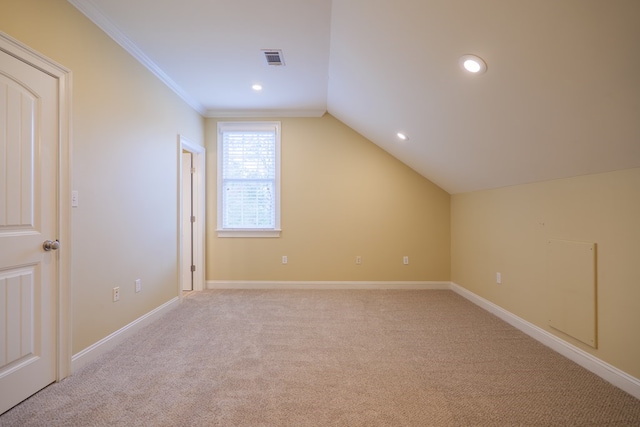 additional living space featuring light colored carpet, visible vents, lofted ceiling, and baseboards