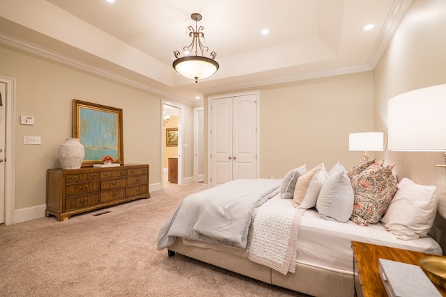 bedroom featuring crown molding, a closet, a raised ceiling, light carpet, and baseboards