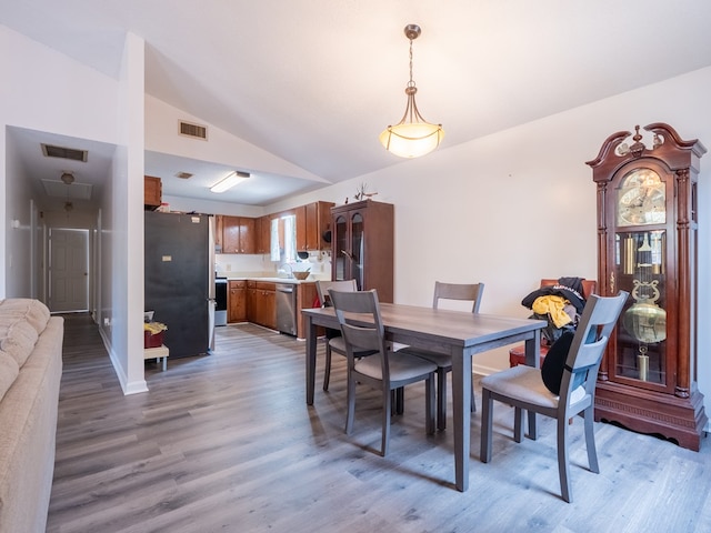 dining area featuring lofted ceiling and light hardwood / wood-style flooring