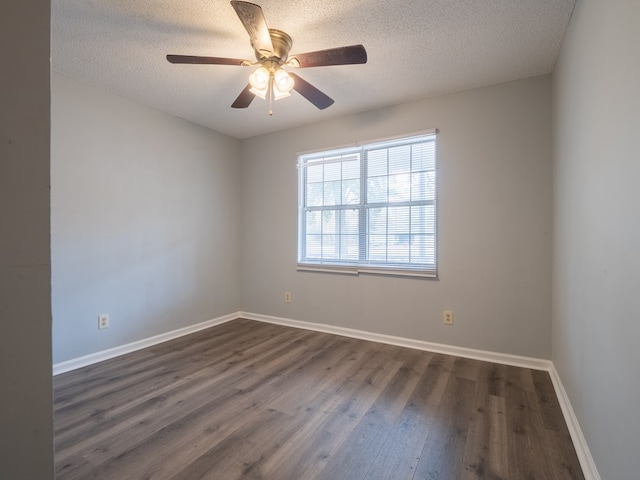 empty room featuring ceiling fan, dark hardwood / wood-style flooring, and a textured ceiling