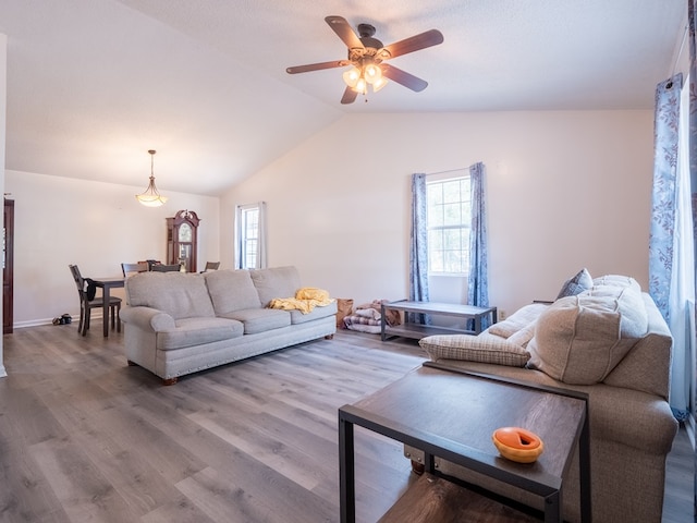 living room with ceiling fan, wood-type flooring, a healthy amount of sunlight, and vaulted ceiling