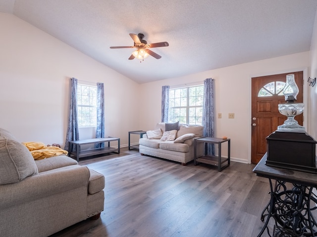 living room with dark wood-type flooring, ceiling fan, lofted ceiling, and a textured ceiling