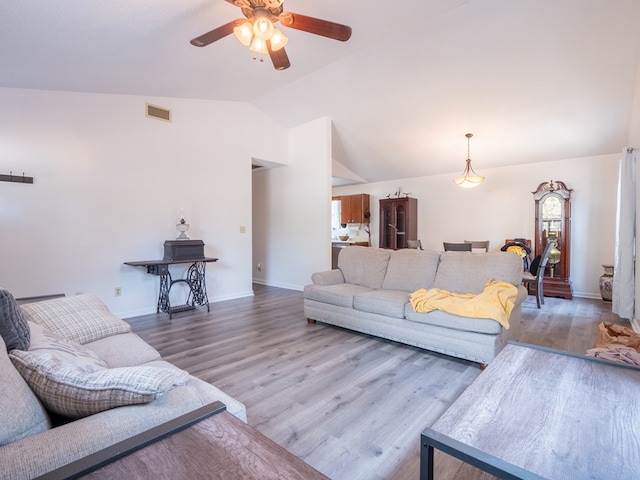 living room featuring wood-type flooring, vaulted ceiling, and ceiling fan