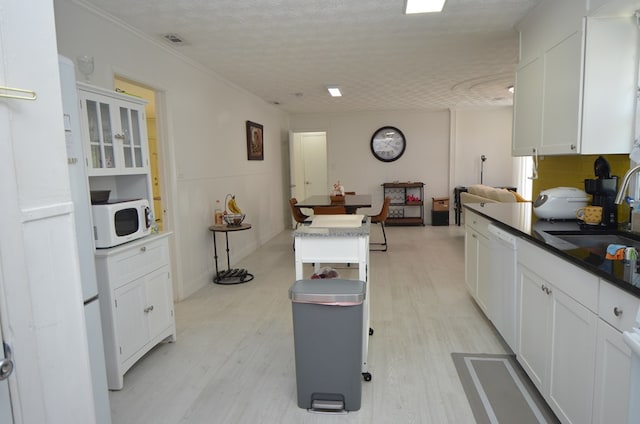 kitchen with white cabinetry, sink, white appliances, and a kitchen island