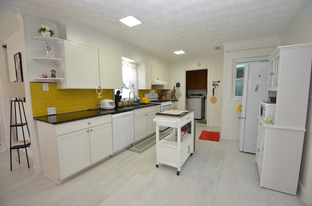 kitchen featuring white cabinetry, sink, white appliances, and light wood-type flooring