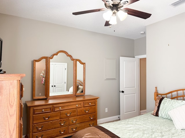 bedroom with visible vents, ceiling fan, a textured ceiling, and baseboards