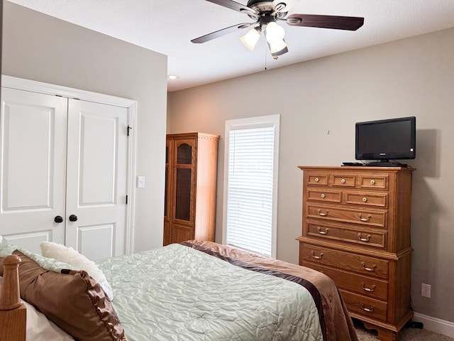 bedroom with a ceiling fan, a closet, and baseboards