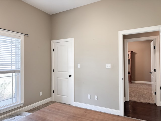 unfurnished bedroom featuring wood finished floors and baseboards