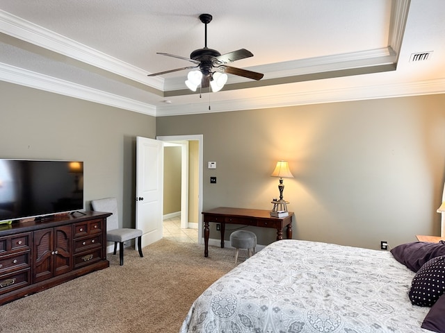 carpeted bedroom with ceiling fan, a tray ceiling, visible vents, and crown molding