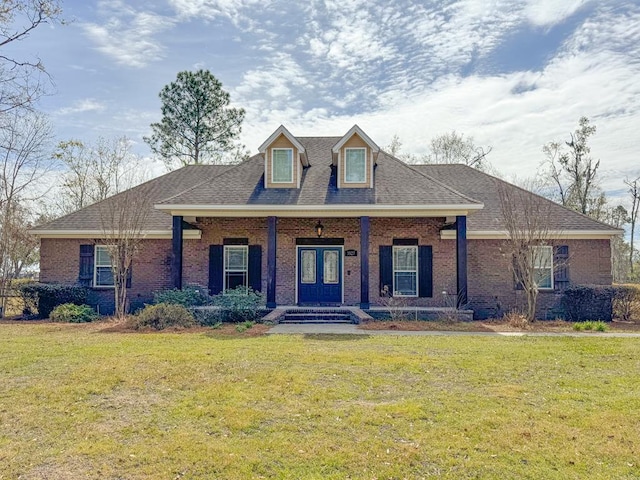 view of front of property featuring covered porch, brick siding, and a front yard