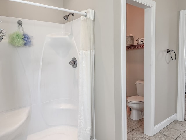 full bathroom with toilet, baseboards, and a shower with shower curtain