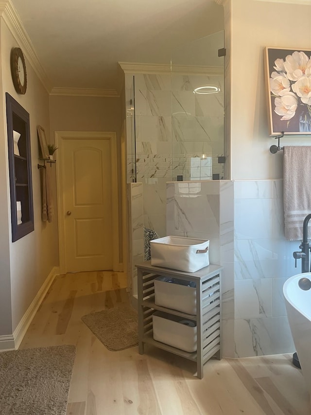 bathroom featuring vanity, wood finished floors, a marble finish shower, crown molding, and tile walls