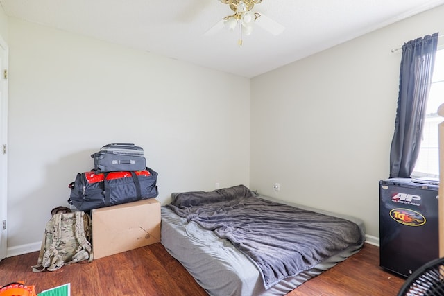 bedroom featuring a ceiling fan, baseboards, and wood finished floors