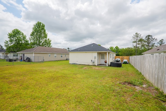 back of house with a lawn and a fenced backyard