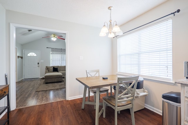 dining space with dark wood-style floors, a healthy amount of sunlight, and ceiling fan with notable chandelier