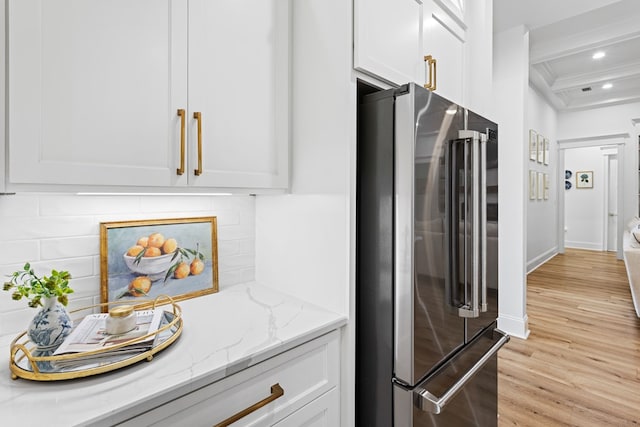 kitchen featuring white cabinets, light wood-style flooring, light stone countertops, and high end refrigerator